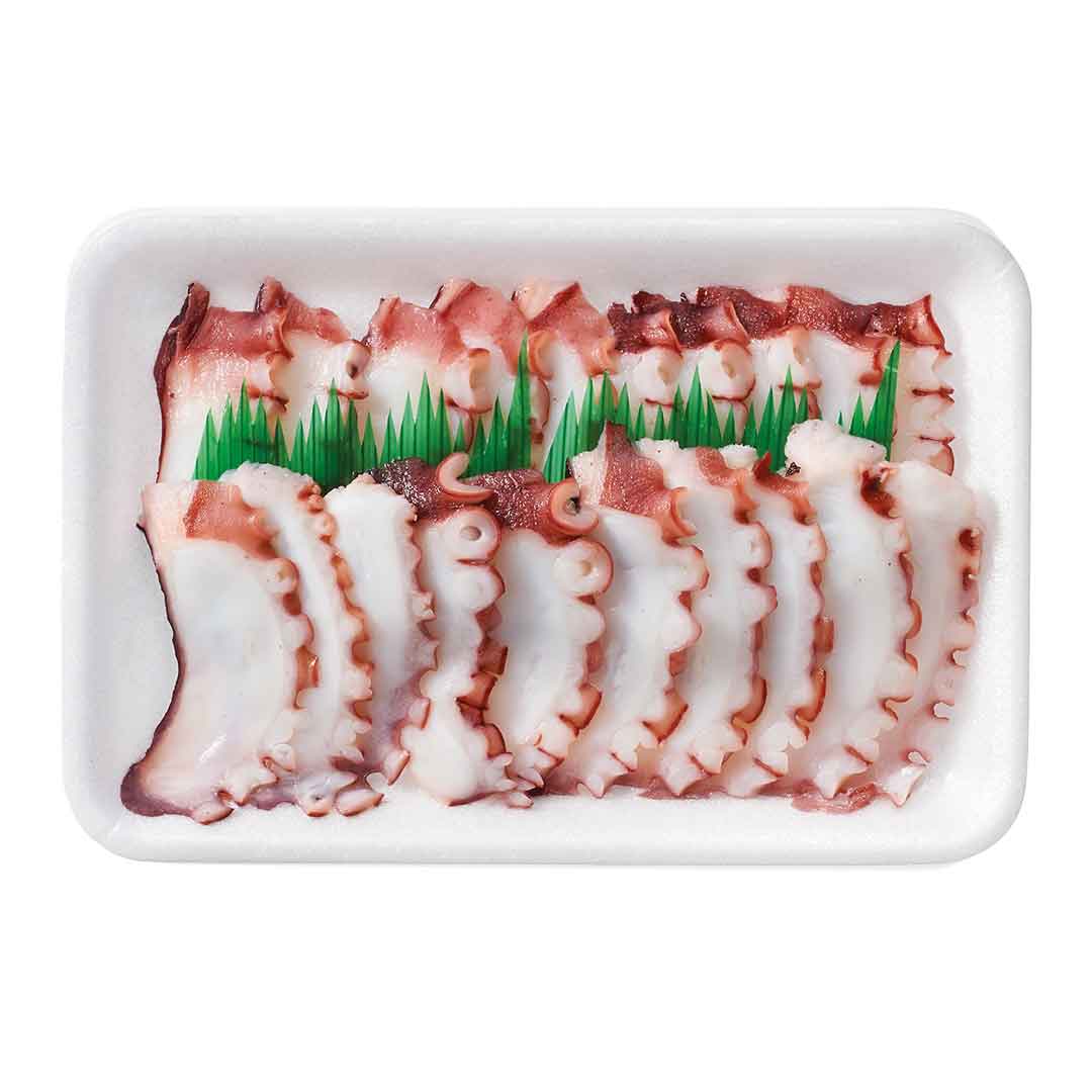 Nahaufnahme einer weißen Styroporschale mit dünn geschnittenen Oktopus-Tentakeln, dekoriert mit grünen Kunststoffblättern, bereit zur Zubereitung von Sushi oder Sashimi