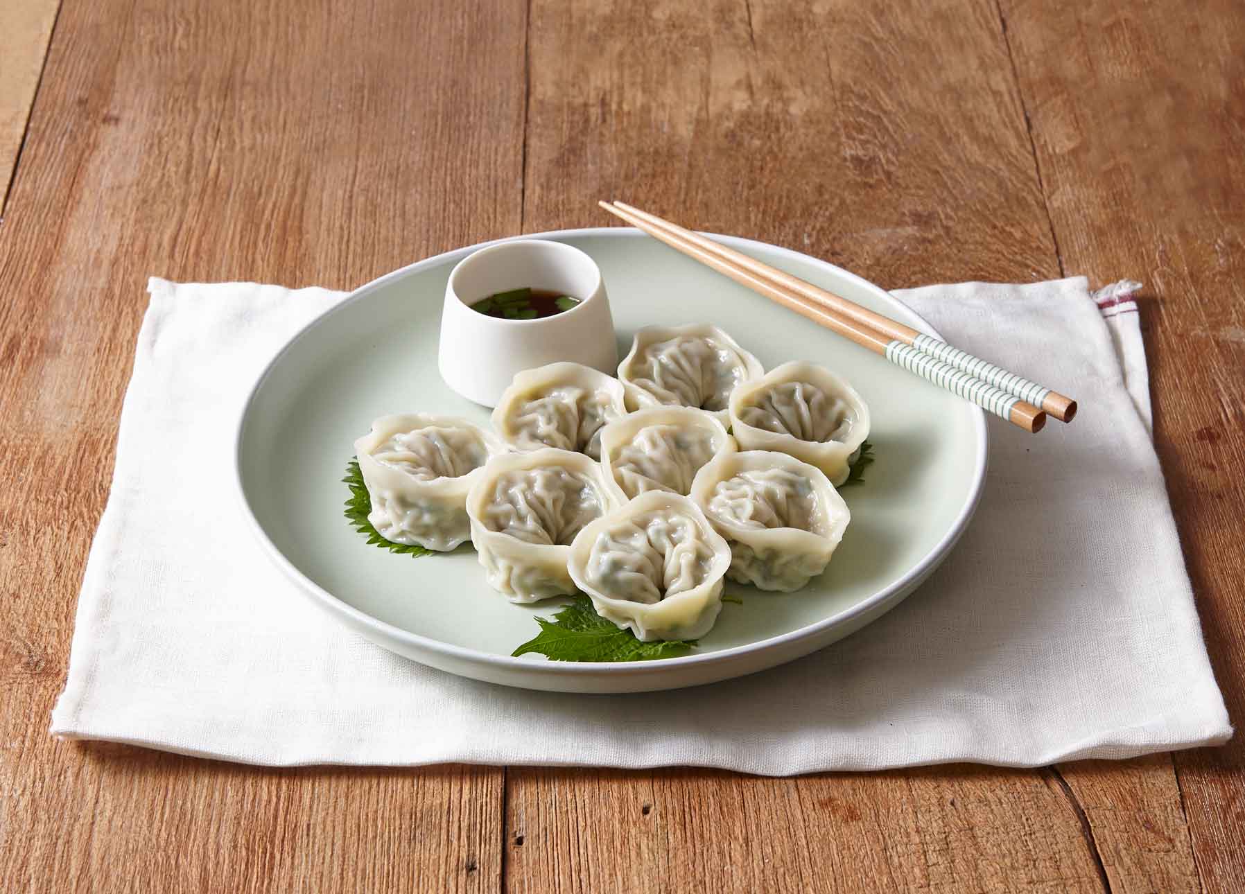 Teller mit koreanischen Mandu-Dumplings und Sojadip