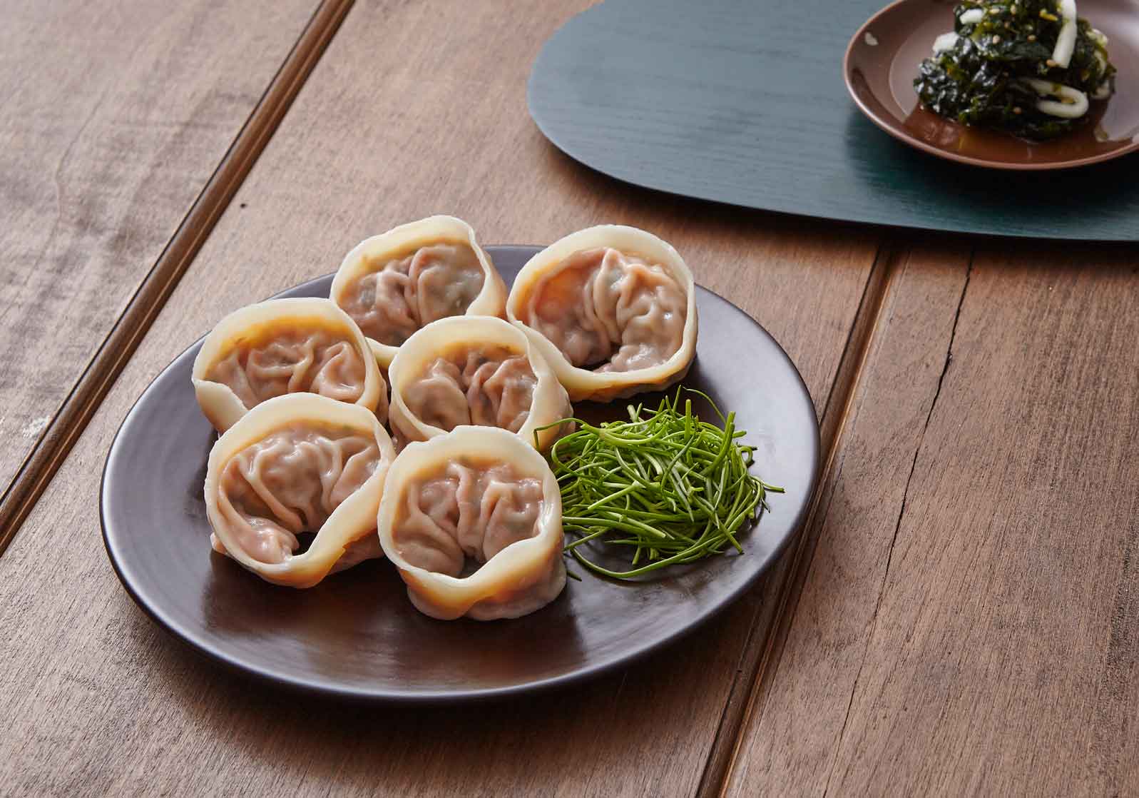 Teller mit gedämpften Dumplings und frischem Gemüse