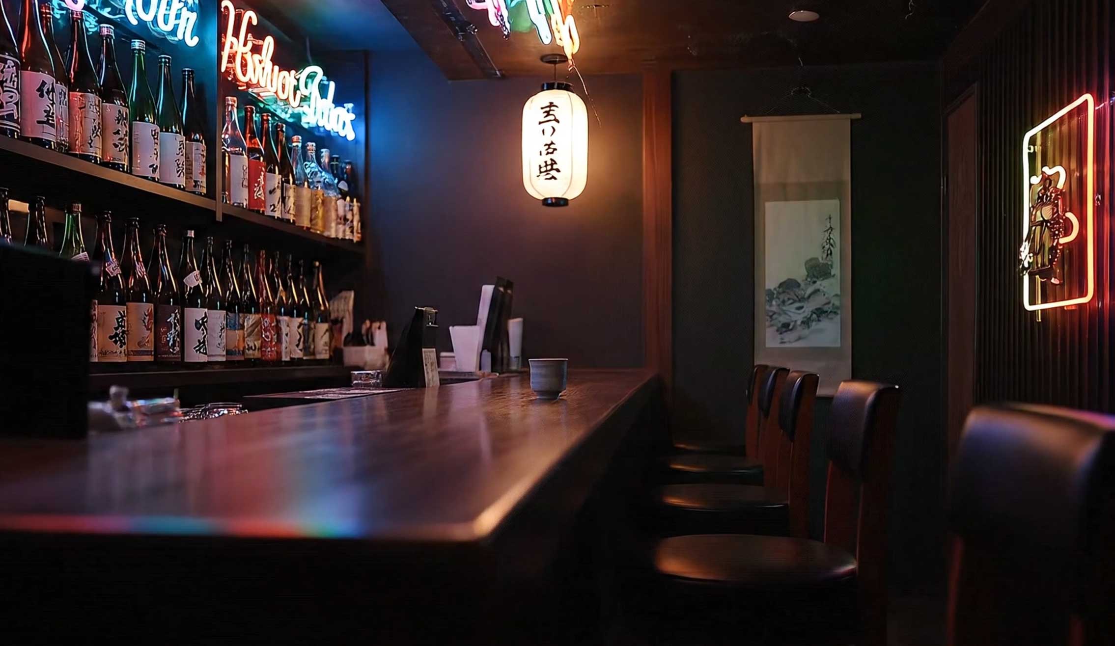 Gemütliche japanische Bar: lange Holztheke mit Hockern, Regal voller Sake-Flaschen, leuchtende Neon-Schrift und Papierlaterne im warmen Licht