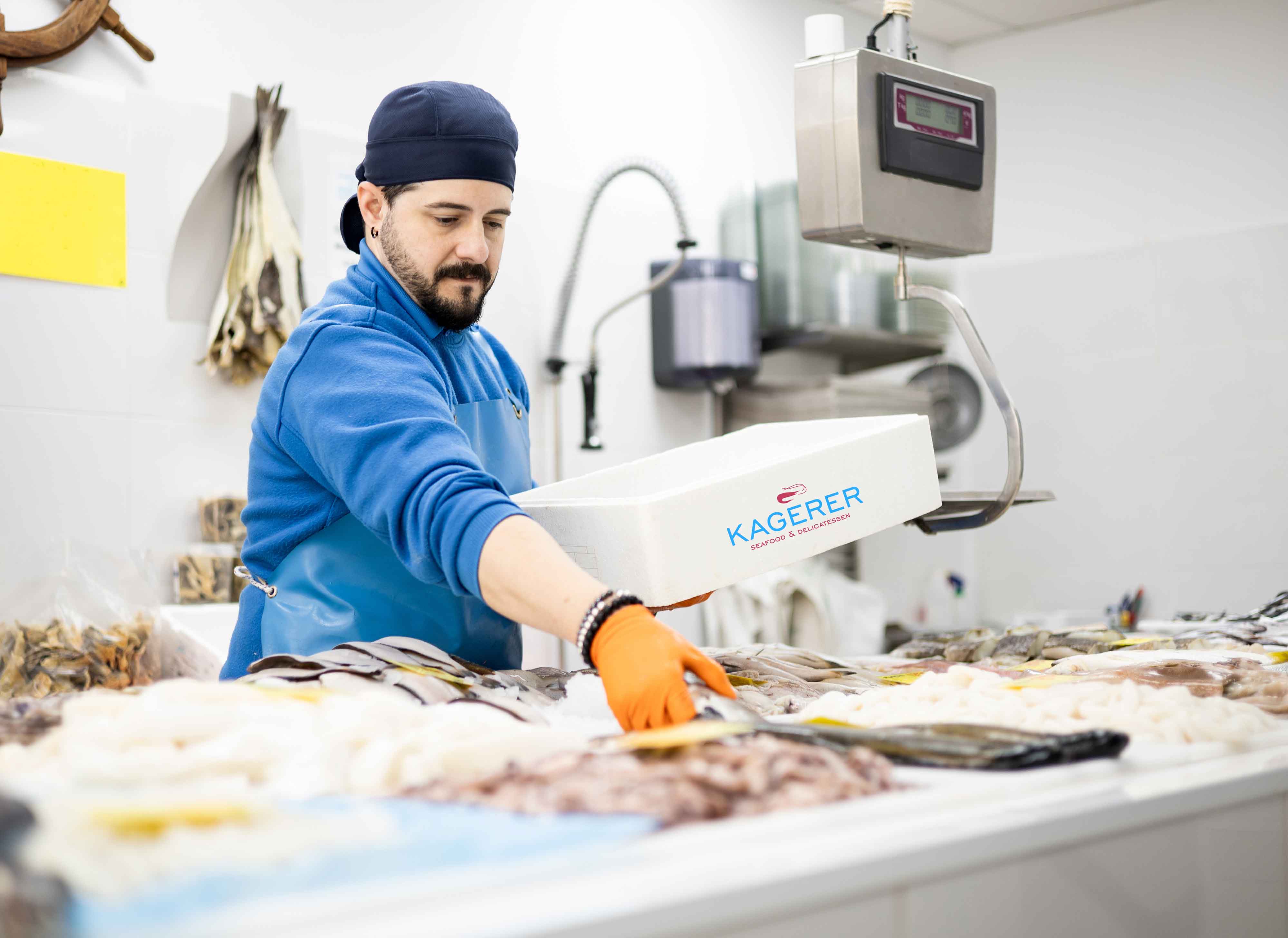 Mitarbeiter sortiert frischen Fisch und Meeresfrüchte auf Eis an der Fischtheke, mit digitaler Waage im Hintergrund